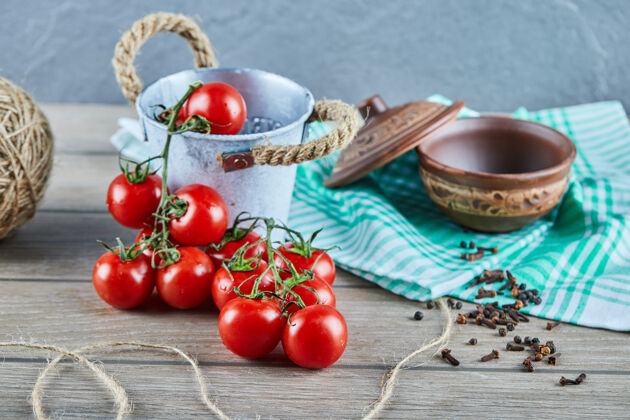 蔬菜一桶西红柿和丁香放在空碗的木桌上有机碗吃
