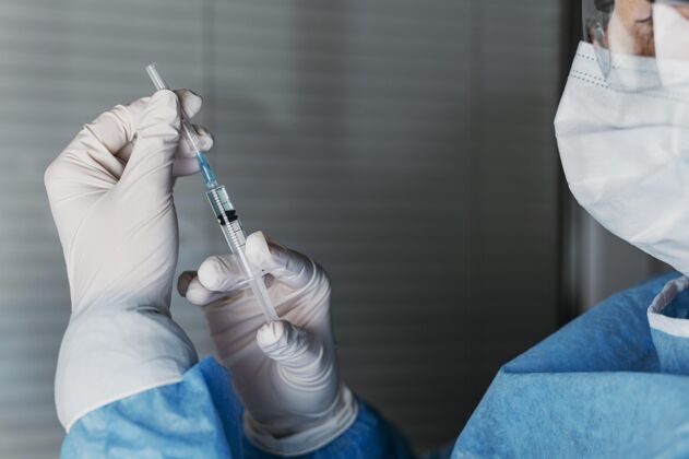 预防医生拿着疫苗瓶 戴着防护装备工作工作注射器