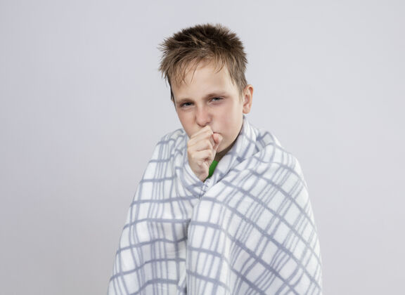 病生病的小男孩裹着毯子站在白墙上咳嗽 感觉不舒服不舒服感觉咳嗽