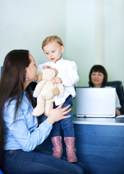 女性妈妈在医生办公室招待女儿患者儿科医生欢呼