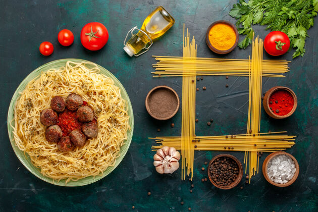 食用坚果俯瞰美味的意大利面食 配肉丸子和番茄酱 放在深蓝色桌上 面食 意大利餐沙司意大利深蓝色