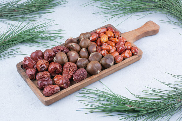 坚果有机栗子和银色浆果放在木板上新鲜零食栗子