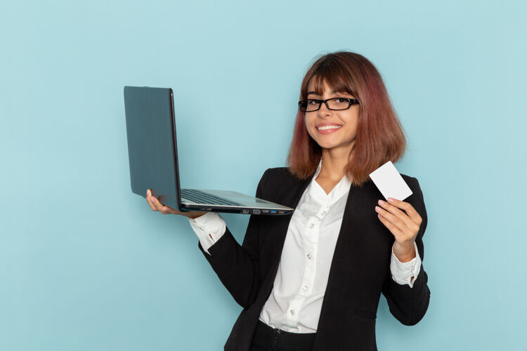 董事正面图：蓝色表面上手持卡片和笔记本电脑的女上班族商务女性笔记本电脑忙碌
