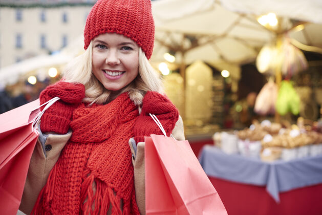 户外带满购物袋的女人女人圣诞市场冬装
