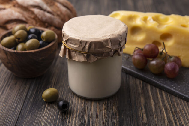 奶酪正面图：马斯丹奶酪架上放着葡萄 桌上放着橄榄和酸奶酸奶熟食店葡萄