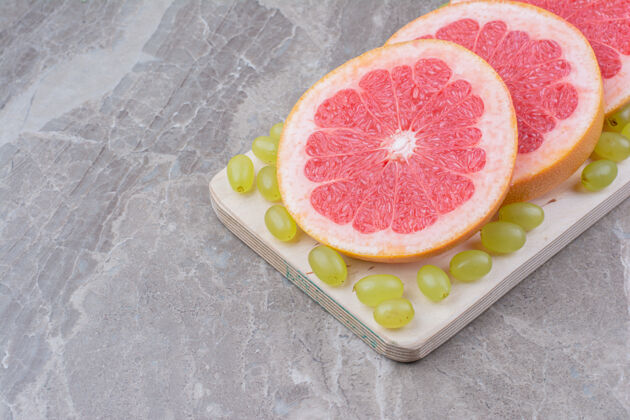 水果柚子片和葡萄放在木板上柑橘健康天然