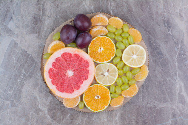 新鲜柑橘类水果 李子和葡萄放在木片上健康顶视图葡萄