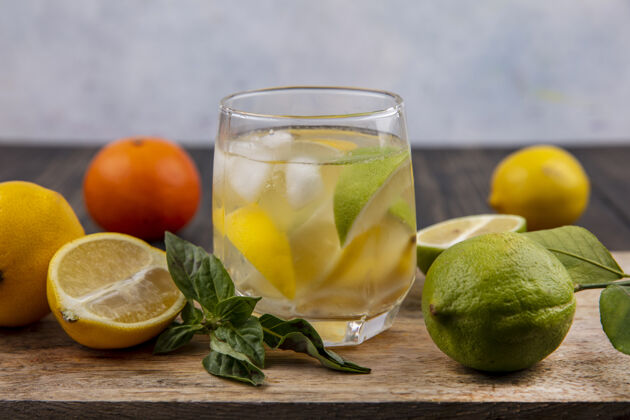 柠檬在砧板上用薄荷柠檬和青柠楔子装一杯水板水酸橙