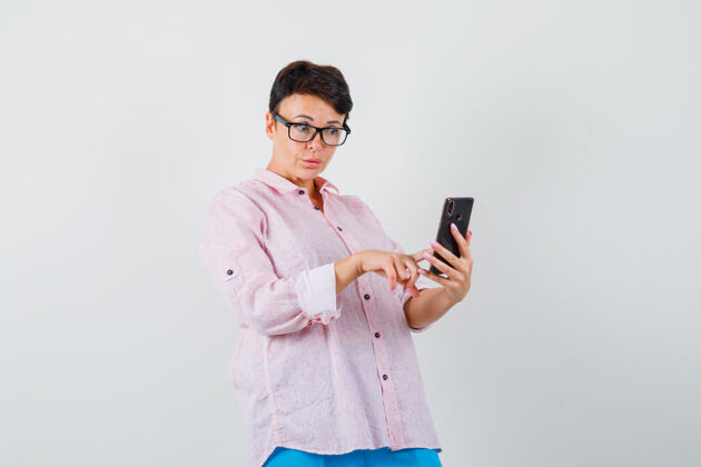 成年人女的用手机穿粉色衬衫 看起来很忙 前视图年轻人面罩防护
