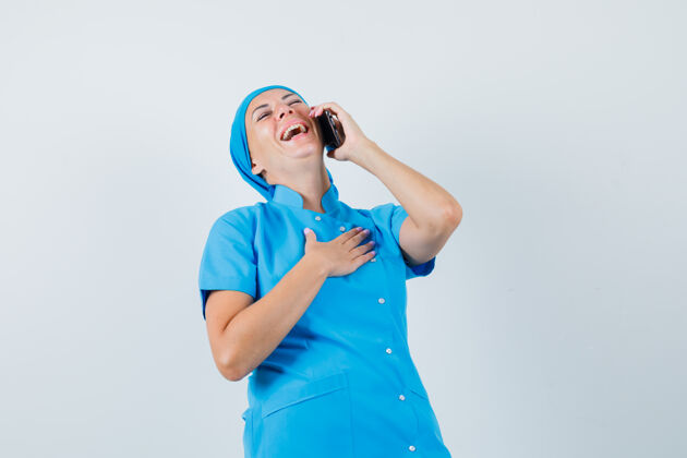 制服身穿蓝色制服的女医生一边笑一边讲手机 正面照疾病疾病手机