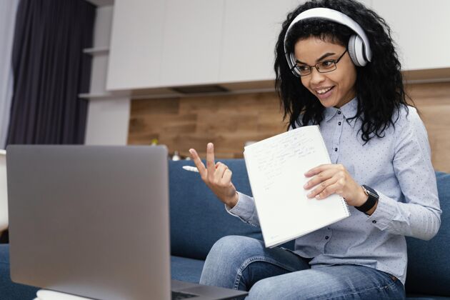 课程笑脸少女带着耳机在网上上学班级在线笔记本电脑