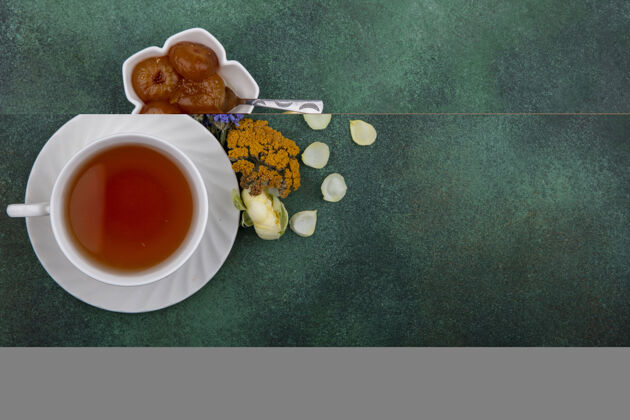 果酱顶视图复制空间一杯茶与无花果果酱和鲜花的绿色背景花顶部空间