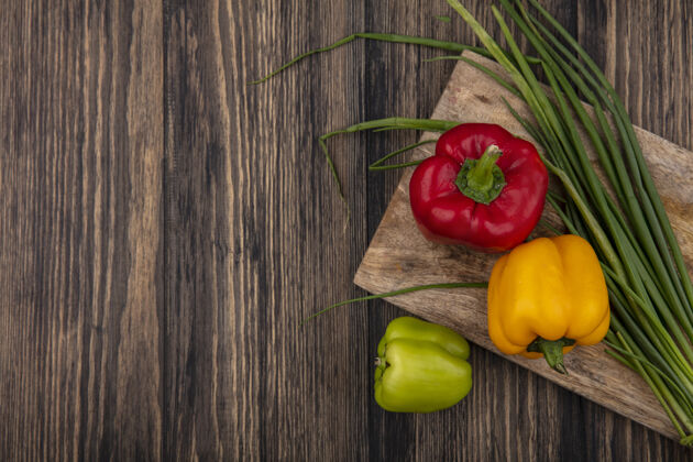 蔬菜顶视图复制空间彩色甜椒与绿色洋葱在砧板上的木制背景铃铛顶部食物