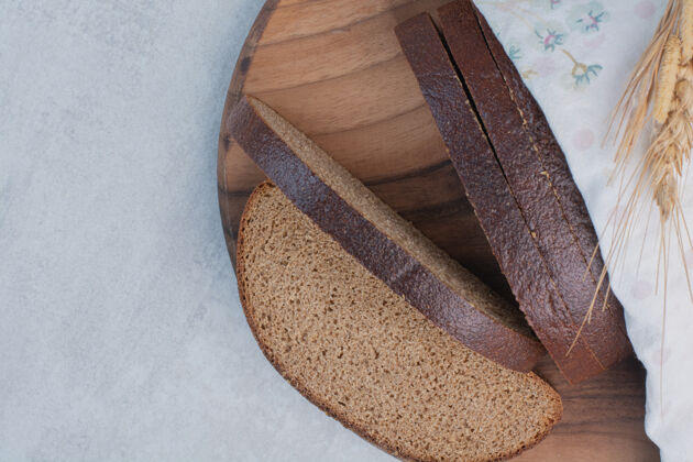 面包房在木板上放几片新鲜的棕色面包棕色糕点切片面包