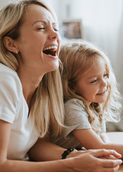 年轻妈妈和女儿在数字平板电脑上看动画片欢呼享受女性