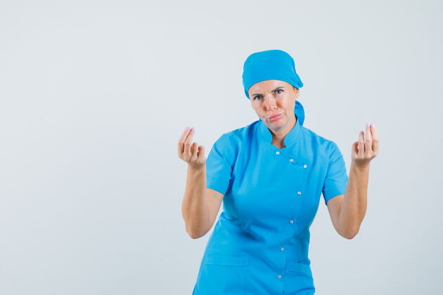 护士穿着蓝色制服的女医生做着赚钱的手势 看上去很穷 前视图实验室女人制服