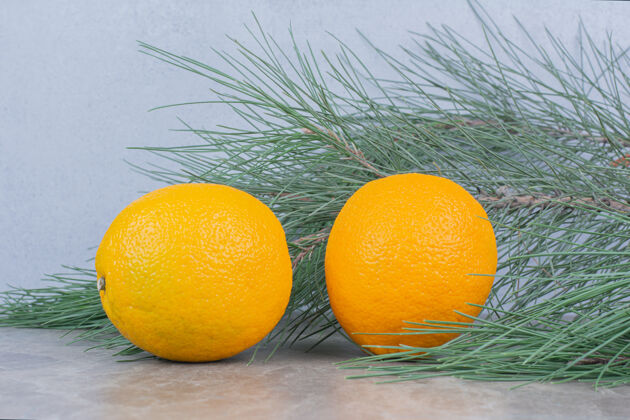 新鲜两个多汁的柠檬放在大理石桌上树枝天然热带