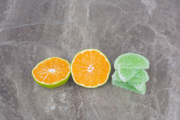 果冻新鲜的橘子片和甜甜的果酱放在大理石背景上新鲜糖美味