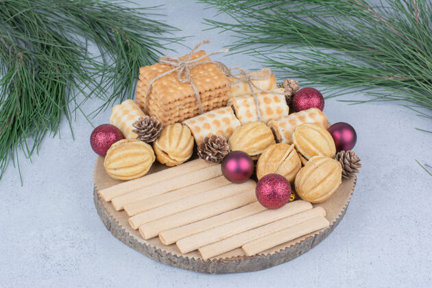 甜点各种饼干和圣诞装饰品放在木板上小吃干美味