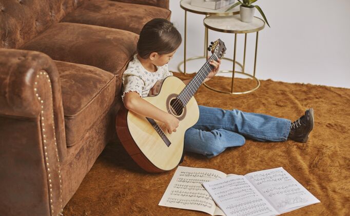 音乐家在家弹吉他的小女孩乐谱乐器学习