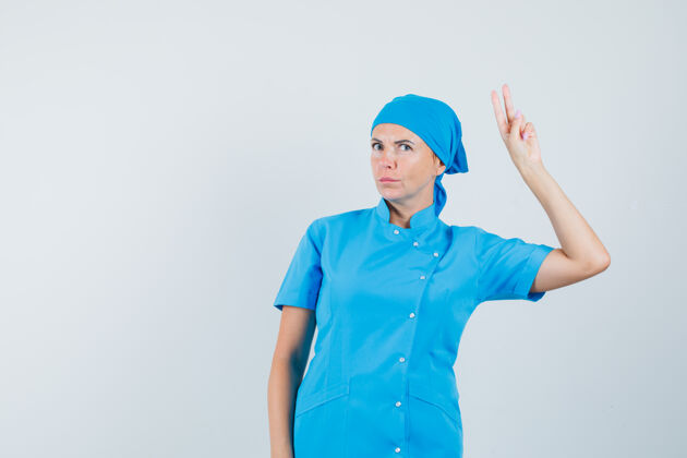 诊所身着蓝色制服的女医生 展现胜利姿态 看上去自信满满 正面照手势疾病诊断