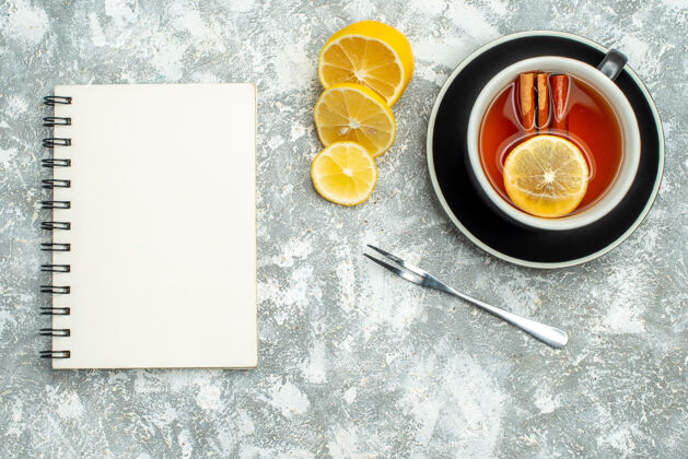 早餐顶视图一杯茶柠檬片笔记本灰面上的自由空间图钉吃顶部