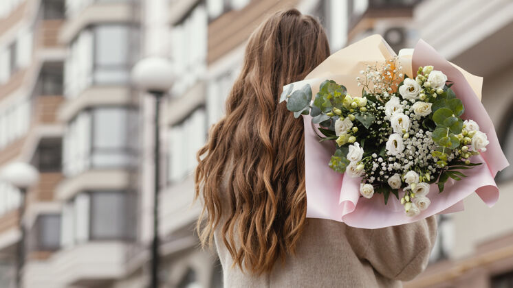城市后视图优雅的妇女举行花束户外复制空间布置季节