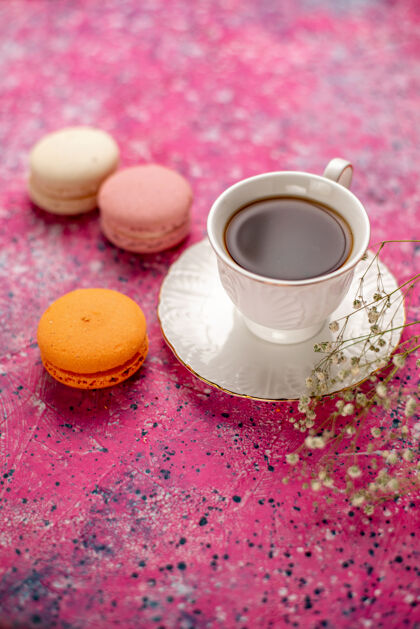 茶碟正面图：茶杯放在盘子里 粉色桌子上放着法国马卡龙盘子杯子茶