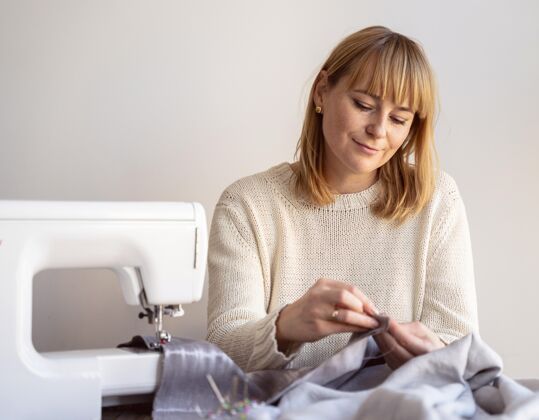 服装裁缝女人用针和线来缝纫面料工具裁缝