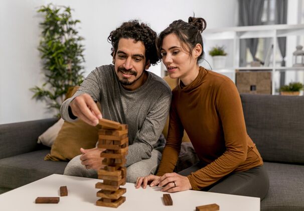 丈夫夫妻俩在室内玩木塔游戏斯堪的纳维亚人海格女朋友