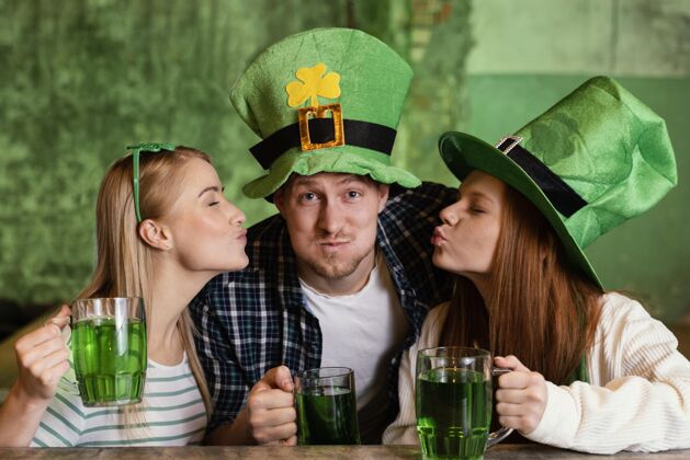庆典快乐的朋友们一起庆祝圣帕特里克节在酒吧与饮料女士品脱饮料