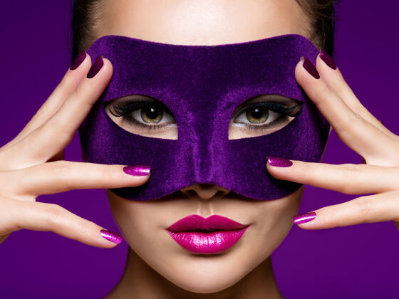 模特一个漂亮女人的肖像 紫色的指甲 脸上戴着紫色的戏剧面具指甲戏剧魅力
