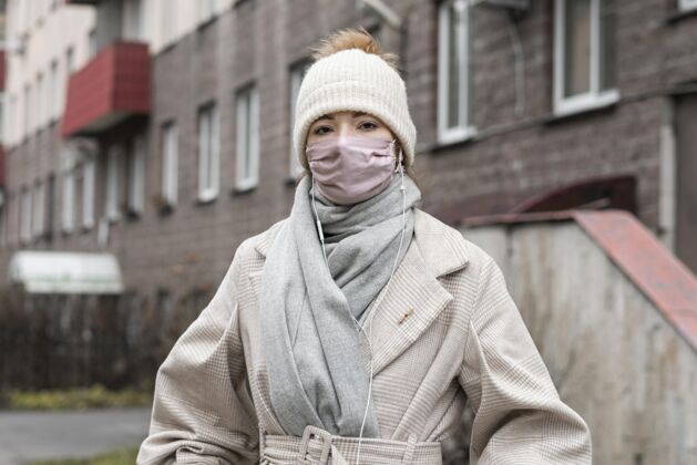 面罩城市里戴着医用面罩的女人的正视图公民人人类