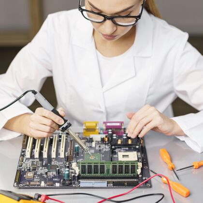 女人高角度的女技师用电子和烙铁技术员实验室技术员创新