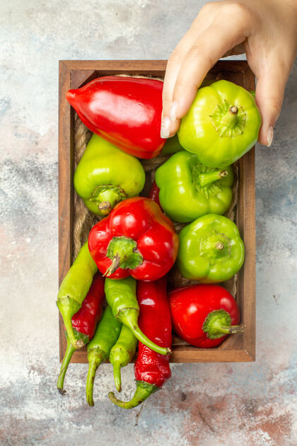 蔬菜顶视图红色和绿色的辣椒辣椒在木箱甜椒在妇女手裸体表面青椒和红椒甜椒女士