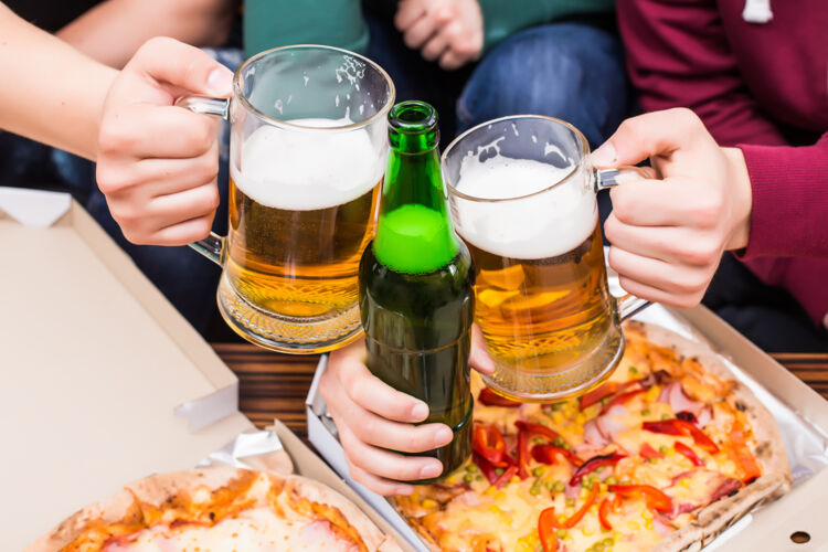 在一起干杯顶视图是男人们喝着啤酒和披萨快乐食物比赛
