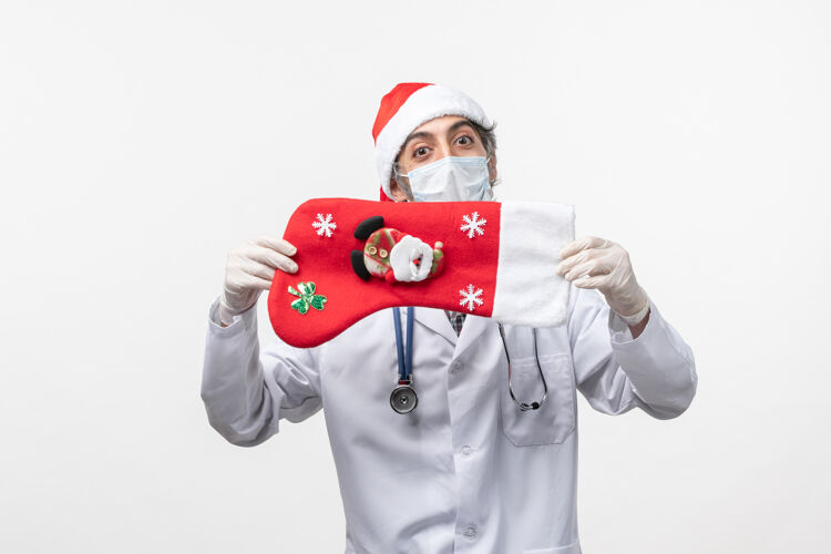 大正面图白色墙上戴着节日袜子的男医生-圣诞病毒袜子表情封面