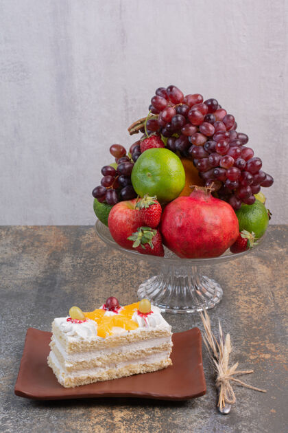 石榴甜甜的水果放在玻璃盘子里 蛋糕放在深色盘子里葡萄草莓新鲜的