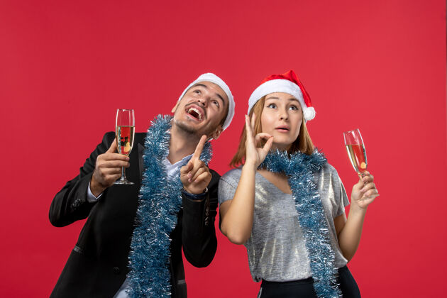成人正面图年轻夫妇在红墙庆祝新年爱圣诞派对饮料表演风景年轻夫妇