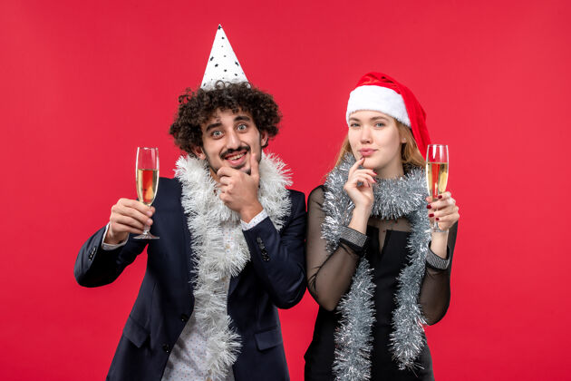 礼服前视图年轻夫妇庆祝新年红墙假日圣诞爱情派对服装美丽公主