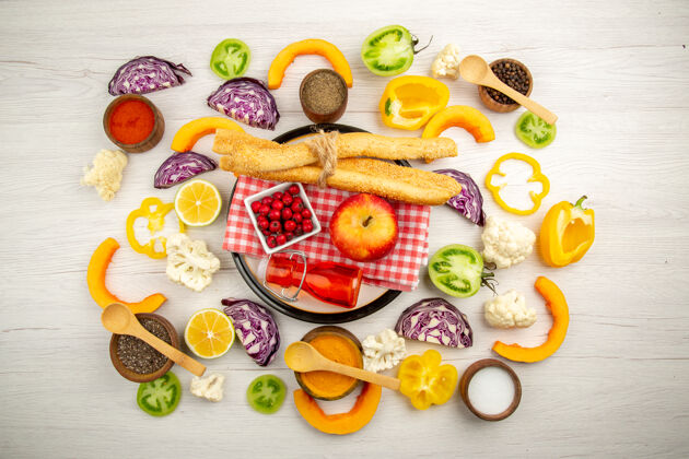 苹果顶视图切碎的蔬菜苹果面包红色瓶子放在餐巾上放在白色盘子里各种香料放在小碗里放在桌子上食品排骨健康