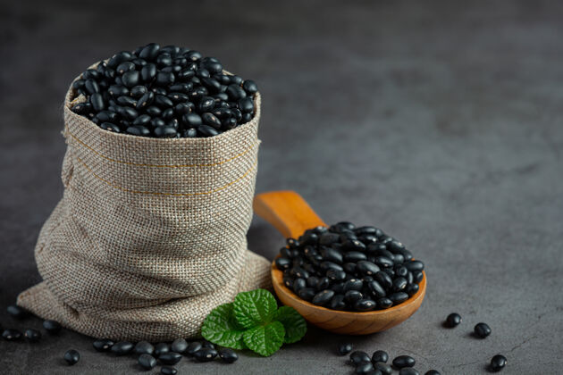 物品黑豆放在小木勺旁边的麻袋里装满了黑豆植物食用滋养