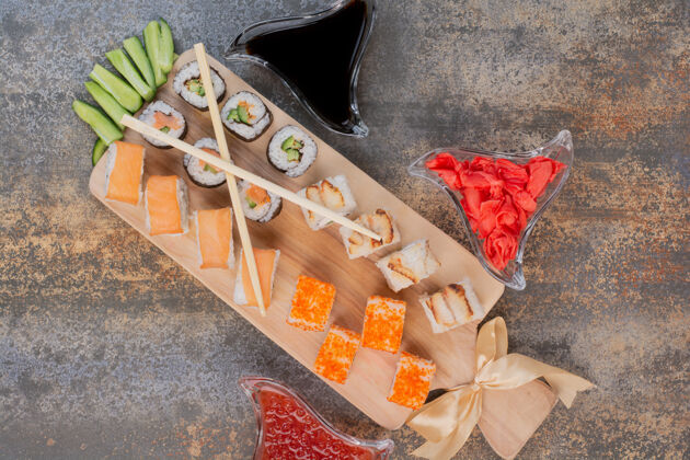 鲜亮的一套美味的寿司 用筷子和姜放在大理石表面鱼金枪鱼五颜六色
