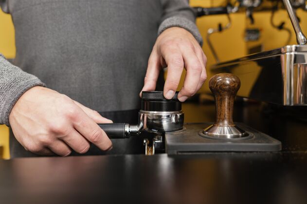 服务员男咖啡师使用专业咖啡机杯的正面图职业雇员男人