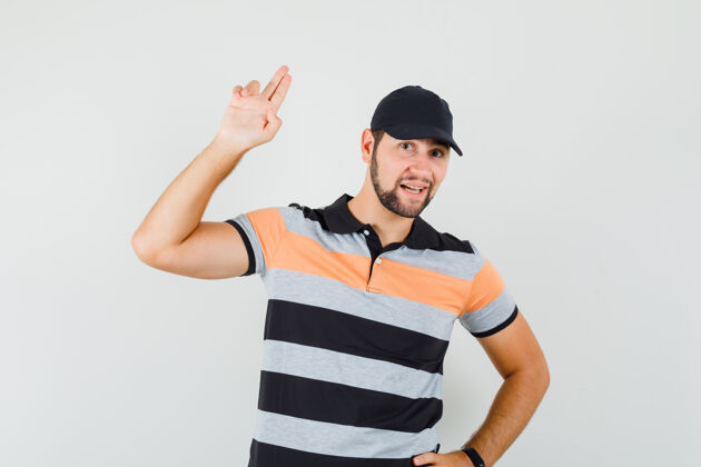 年轻年轻人穿着t恤 戴着帽子 用手和手指做手势 看上去很自信休闲男人手指