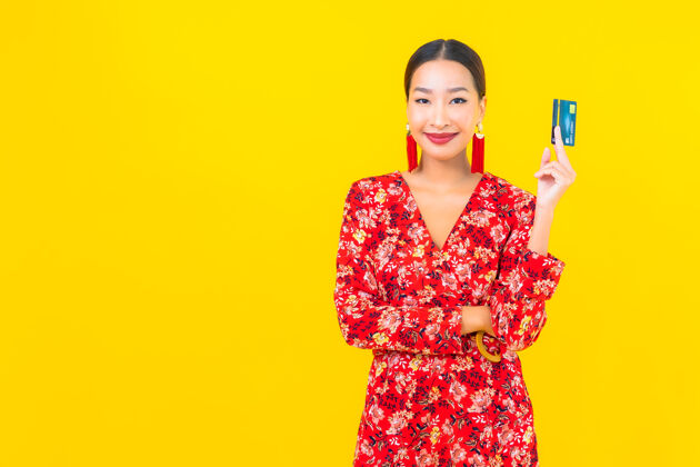 女性肖像美丽的亚洲年轻女子信用卡购物黄色隔离墙肖像女人人