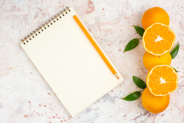 笔记本顶视图新鲜柑桔记事本橙色铅笔明亮孤立的表面信息顶部花
