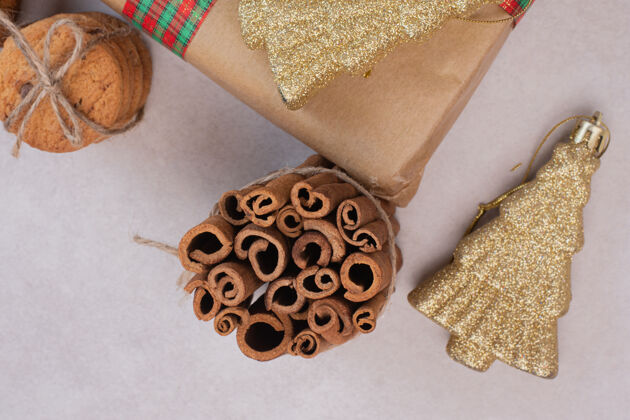 甜点带肉桂棒的绳子饼干和白色表面的圣诞玩具食物装饰糖
