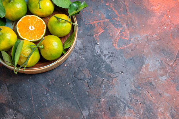 视图顶视图新鲜的柑桔在深红色的表面与自由空间碗多汁柠檬顶部