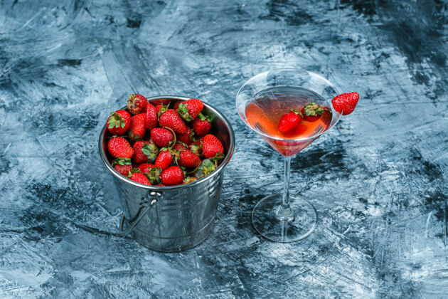 食物高角度观看一杯草莓鸡尾酒 深蓝色大理石表面有一篮草莓水平浆果草莓热带